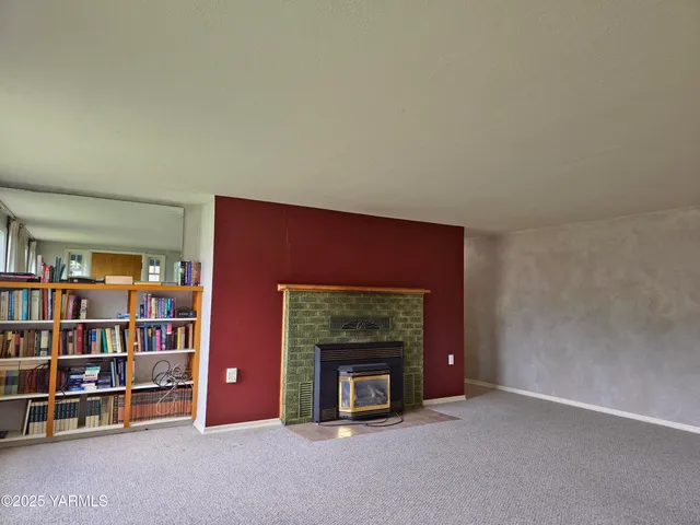 a living room with a bookshelf and a fireplace