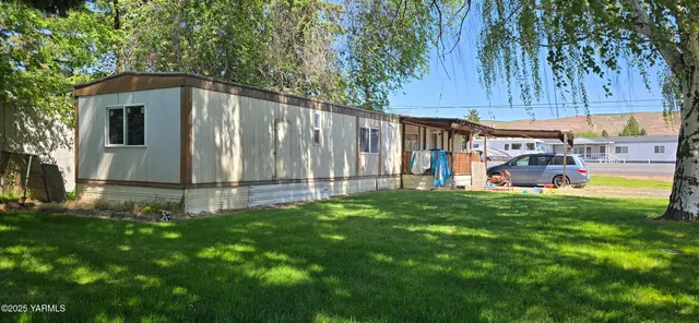 a view of a back yard of the house with a yard