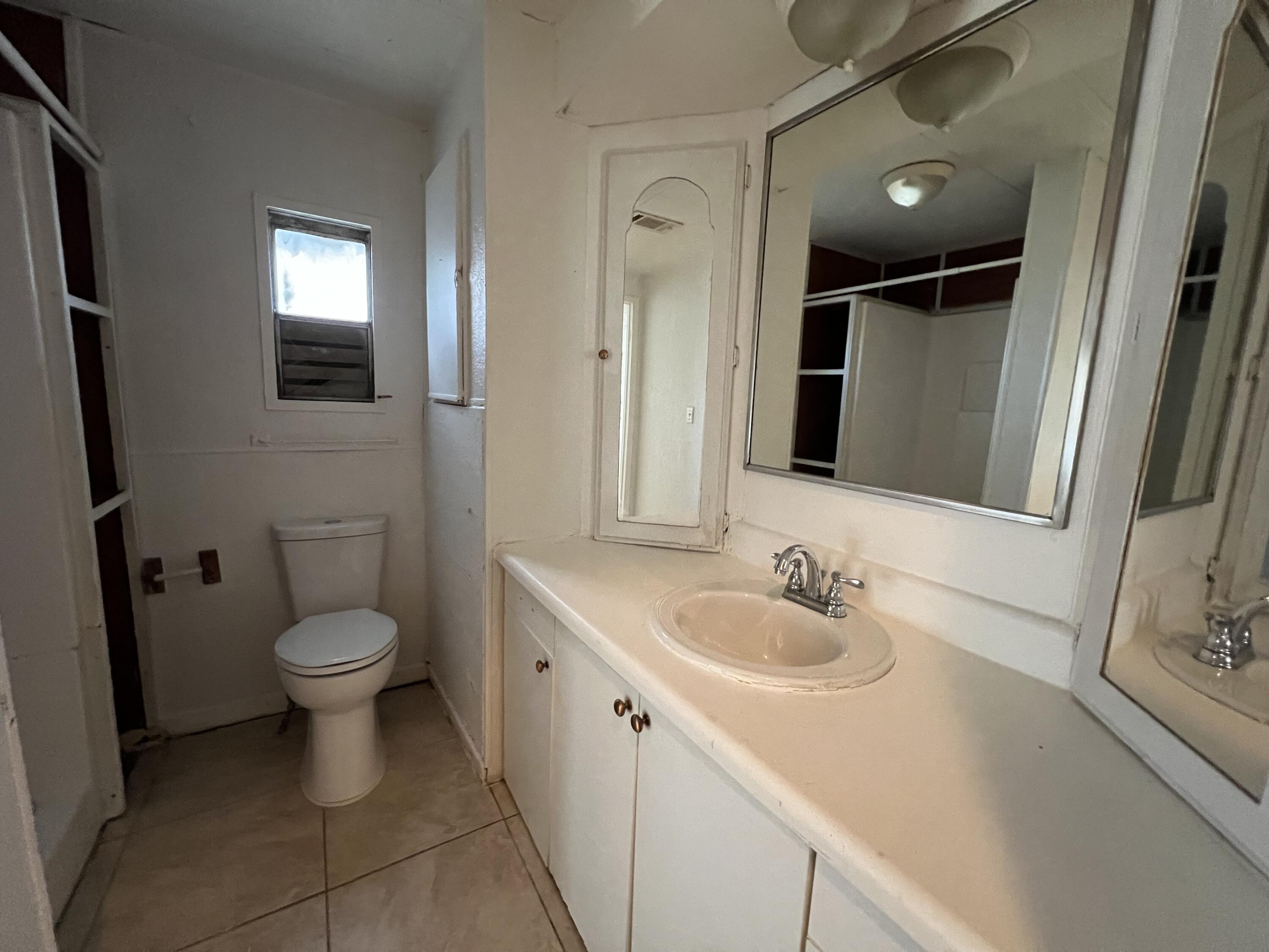 7002 Ash Drive Cocoa, FL 32927 - Photo 11 of 18 a bathroom with a toilet sink and mirror