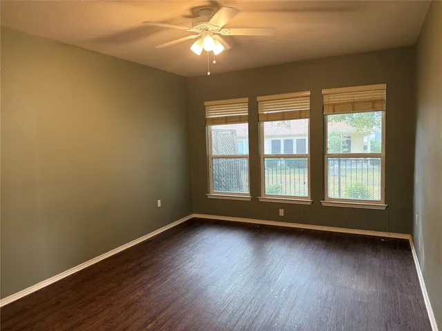 a view of room with window ceiling fan and hardwood floor