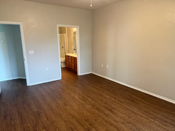 an empty room with wooden floor and closet
