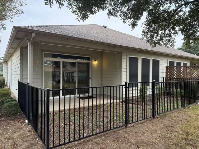 a view of a house with a wooden fence