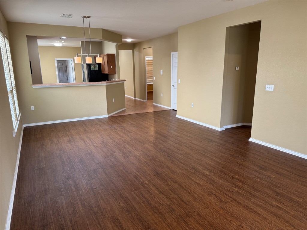 330 Portsmouth Drive Georgetown, TX 78633 - Photo 8 of 16 an empty room with wooden floor and a kitchen