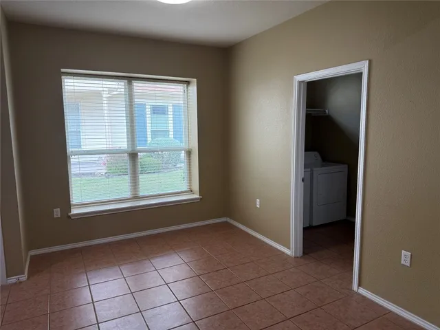 a view of an empty room with window and closet area