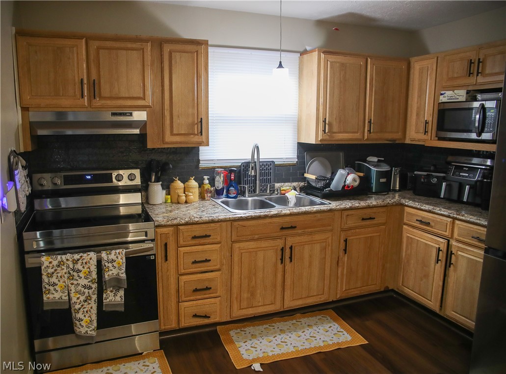 1258 Vane Avenue Akron, OH 44310 - Photo 5 of 12 Kitchen featuring wood-finish cabinetry with dark hardware, granite-look countertops, and a subway tile backsplash