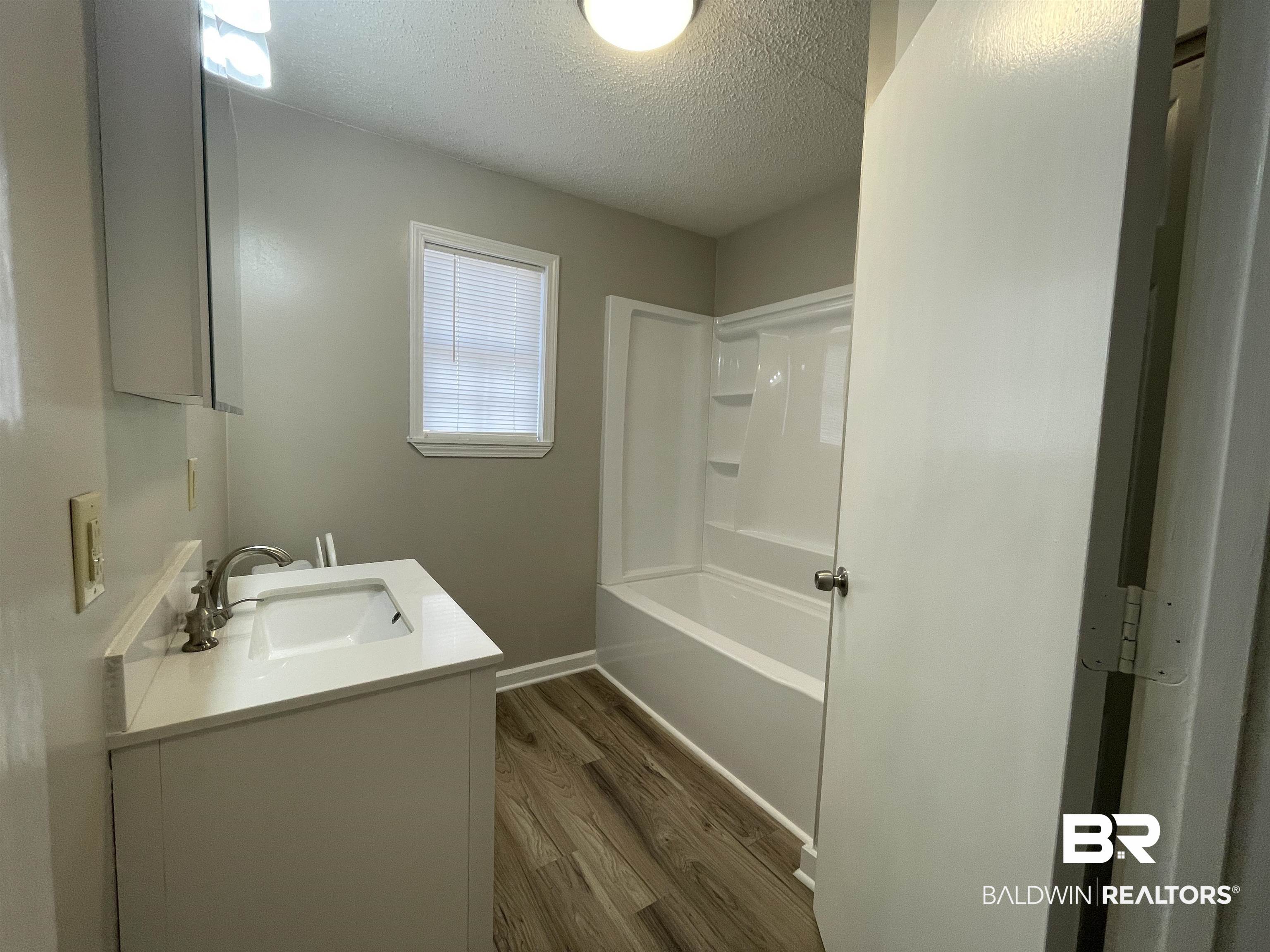 28414 Highway 31 Flomaton, AL 36441 - Photo 9 of 11 Bathroom with vanity, New LVP Flooring, baseboards, and a textured ceiling