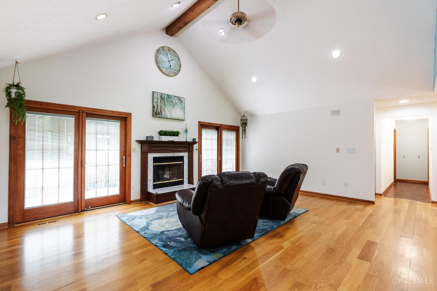623 Ibold Road Loveland, OH 45140 - Photo 6 of 35 The dramatic great room features soaring vaulted ceilings with exposed beam accents, a cozy wood-burning fireplace, and expansive windows and walkout access to the deck via French doors that fill the space with natural light.