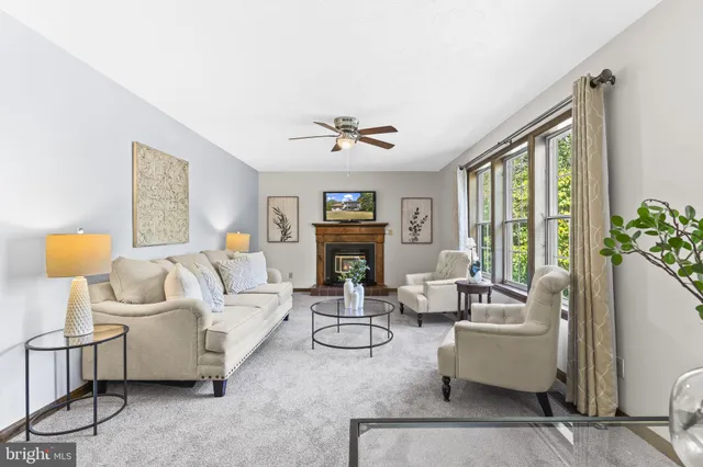 a living room with furniture a fireplace and a large window