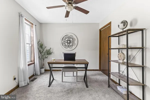 a view of a workspace with furniture and a window