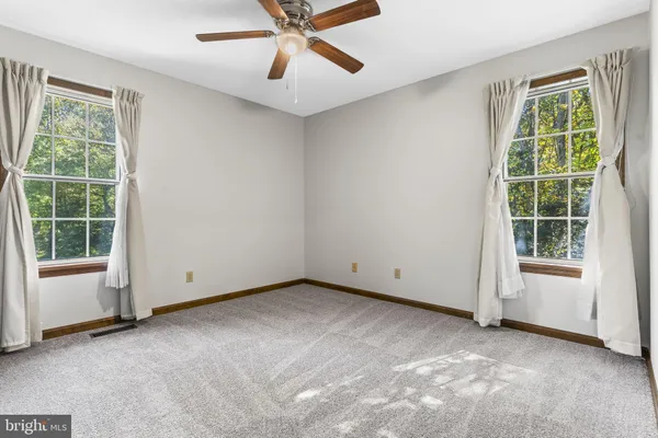 an empty room with a window and a fan