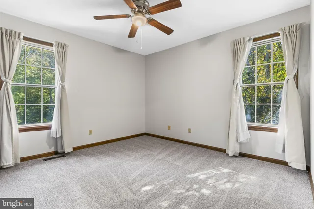 an empty room with a window and a fan