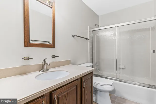 a bathroom with a sink toilet vanity and shower