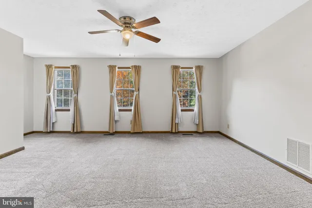 an empty room with closet and ceiling fan