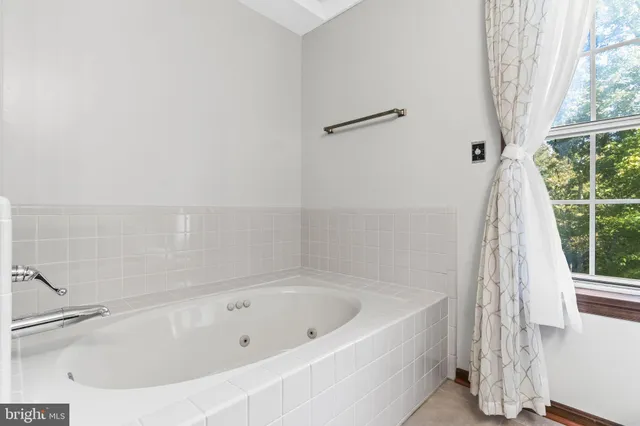 a white bath tub sitting next to a shower