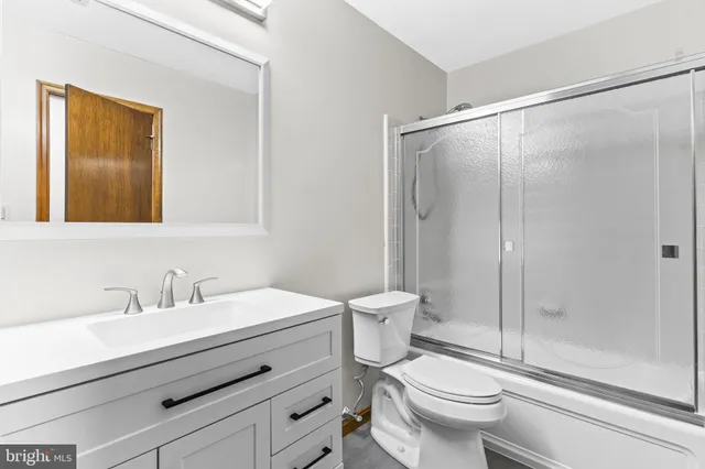 a bathroom with a sink a mirror a toilet and shower