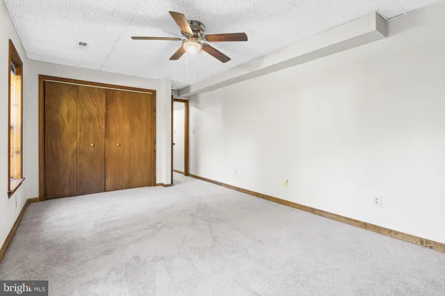 an empty room with a ceiling fan and a window