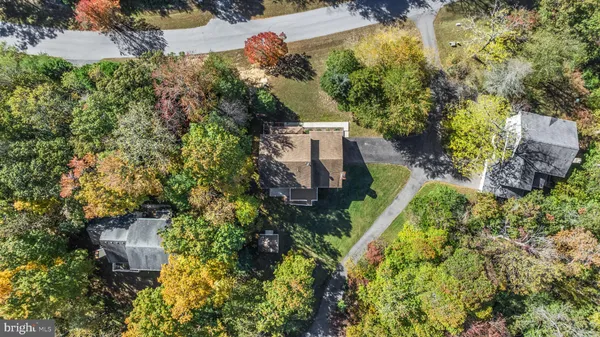 an aerial view of residential house with outdoor space and trees all around