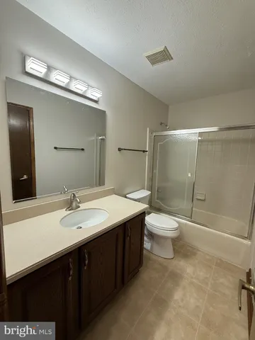 a bathroom with a double vanity sink toilet and shower