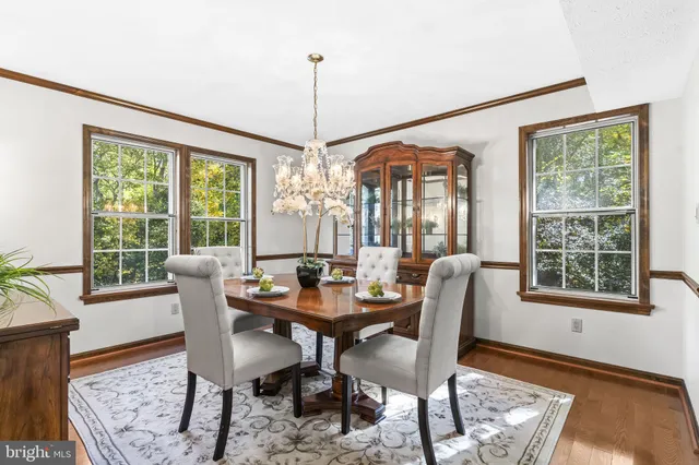 a dining room with furniture a chandelier and wooden floor