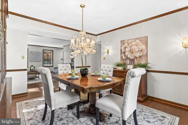 a dining room with furniture a chandelier and wooden floor
