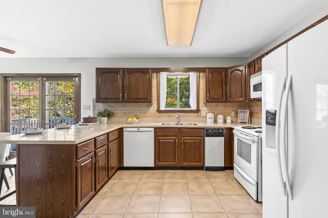 a kitchen with stainless steel appliances granite countertop a stove a sink dishwasher and a refrigerator