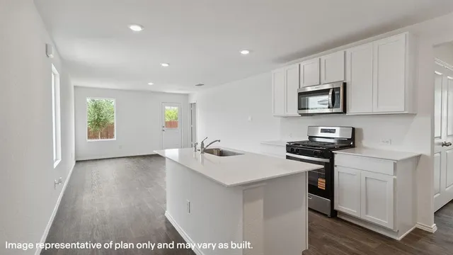 a kitchen with stainless steel appliances a sink stove and cabinets