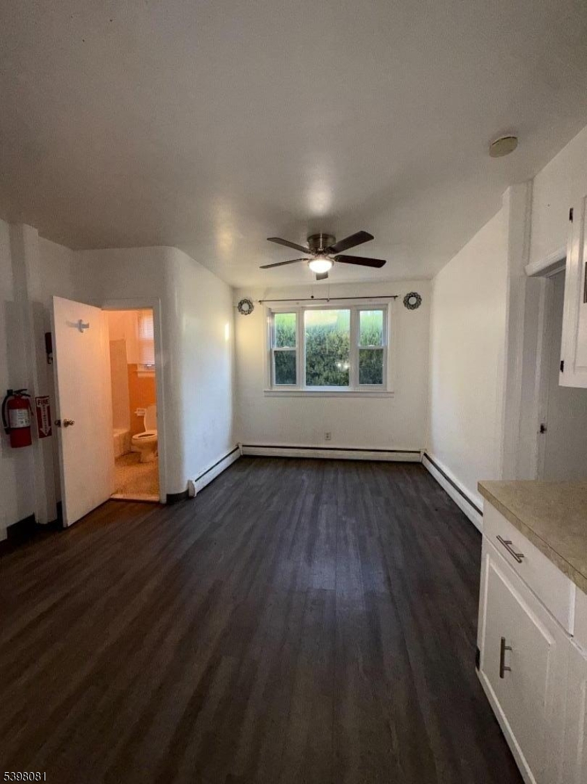 177 9th Street Passaic, NJ 07055 - Photo 2 of 6 an empty room with wooden floor and windows