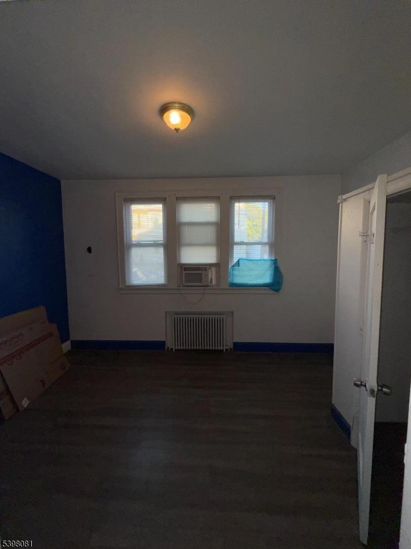 177 9th Street Passaic, NJ 07055 - Photo 5 of 6 an empty room with wooden floor and windows