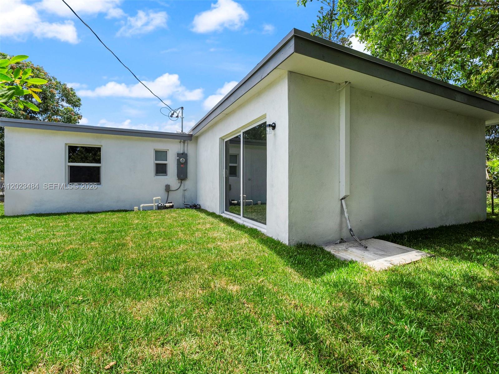 1961 Rutland Street Opa-Locka, FL 33054 - Photo 29 of 33 a backyard of a house with plants and large tree