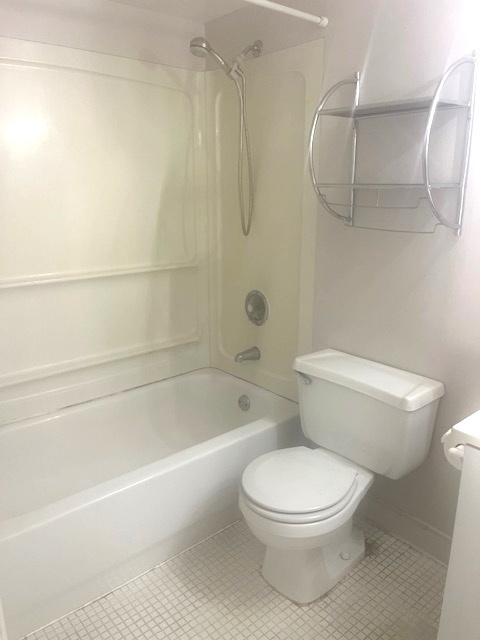 1102 Westover Lane, Unit 1C Schaumburg, IL 60193 - Photo 5 of 8 a white toilet and tub sitting next to a bathroom sink