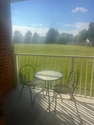a view of a balcony with table and chairs