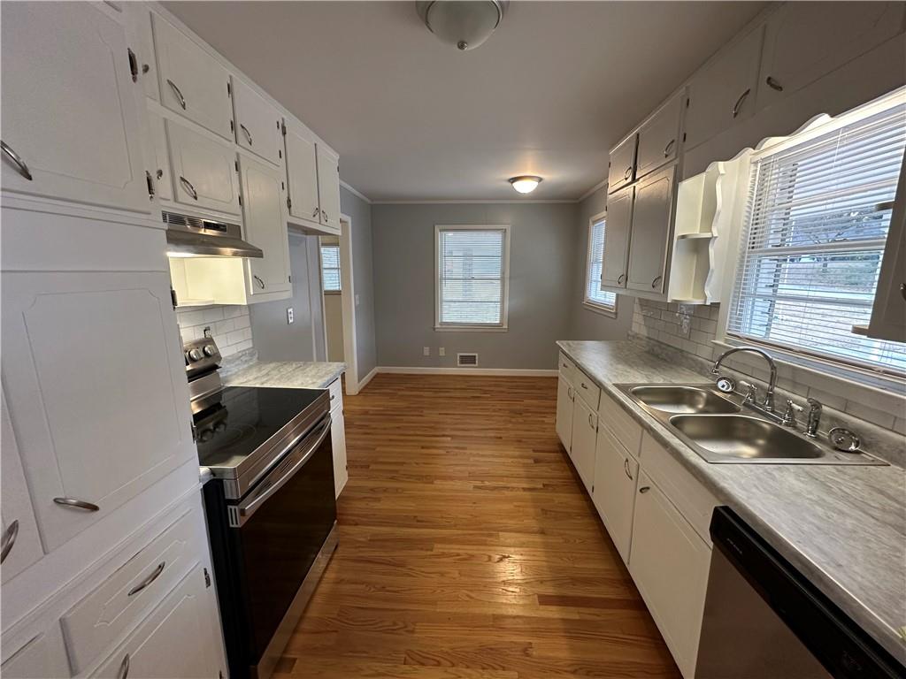 423 Center Circle Southwest Conyers, GA 30094 - Photo 7 of 24 a kitchen with granite countertop stainless steel appliances a sink stove top oven and cabinets