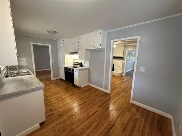 a kitchen with wooden floors and stainless steel appliances