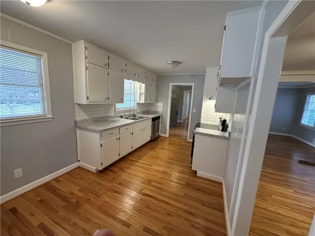 a kitchen with cabinets wooden floor and a fireplace