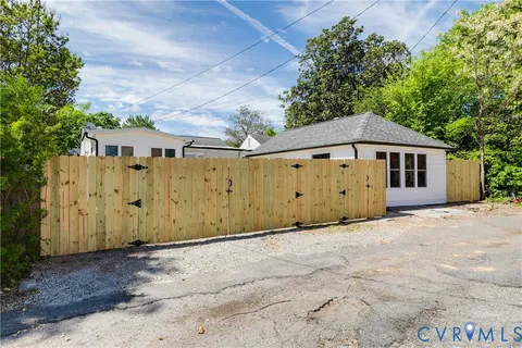 a view of backyard with wooden fence