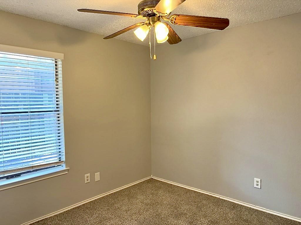 7809 Topawa Cove, Unit B Austin, TX 78729 - Photo 12 of 15 an empty room with a window and a fan