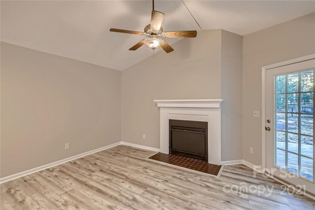 10233 Grand Junction Road Mint Hill, NC 28227 - Photo 2 of 16 a view of an empty room with wooden floor fireplace and a window