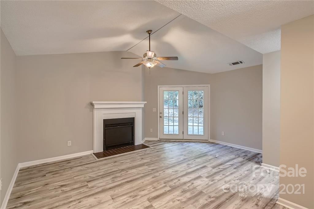 10233 Grand Junction Road Mint Hill, NC 28227 - Photo 3 of 16 a view of an empty room with wooden floor fireplace and a window