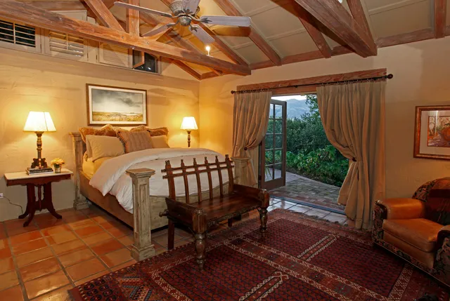 a bedroom with a bed a couch and potted plant