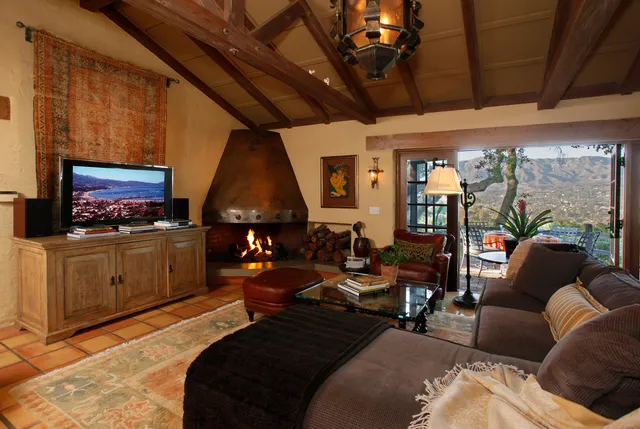a living room with furniture a flat screen tv and a floor to ceiling window