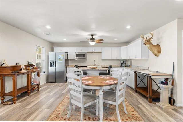 a kitchen with a dining table chairs stove and refrigerator