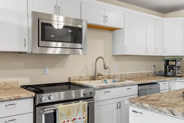a kitchen with stainless steel appliances granite countertop a sink stove and microwave