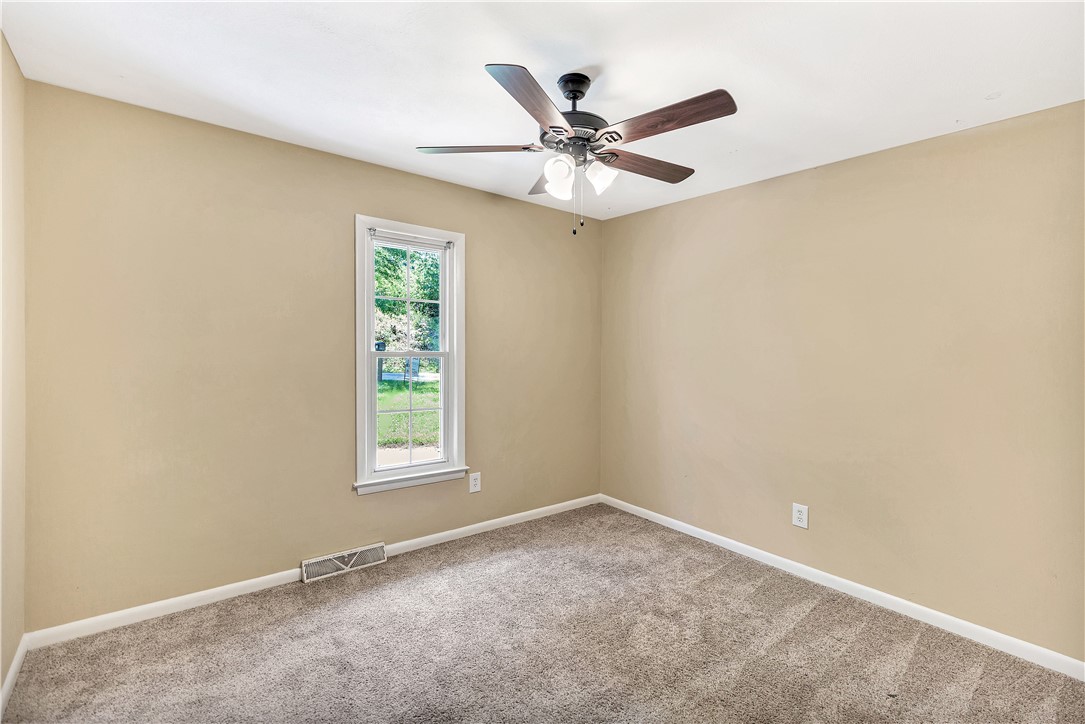2011 Forest Drive Seneca, SC 29672 - Photo 21 of 36 A well-lit bedroom features plush carpeting and a modern ceiling fan, offering comfortable living.