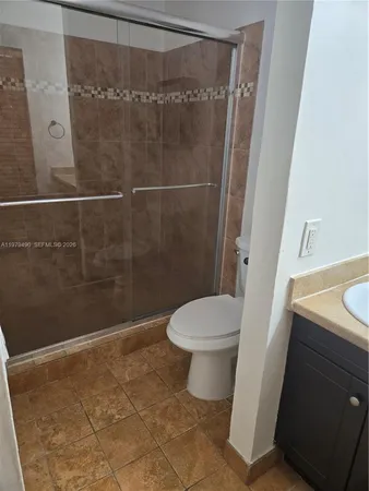 a white toilet sitting next to a shower