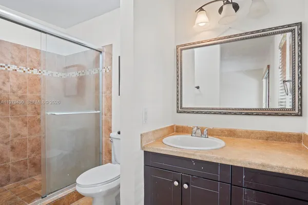 a bathroom with a sink toilet a mirror and shower