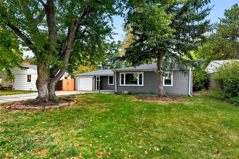 a tree in front of a white house
