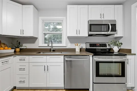 a kitchen with white cabinets and appliances