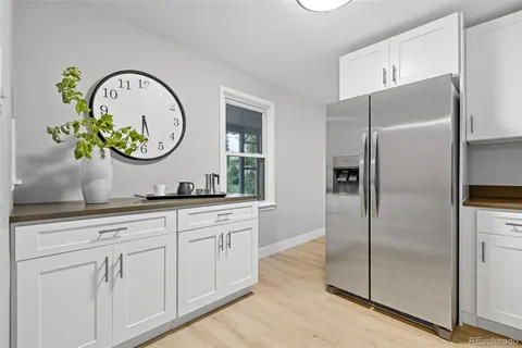 a kitchen with white cabinets a sink and stainless steel appliances