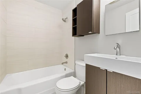 a bathroom with a toilet a sink a mirror and bathtub