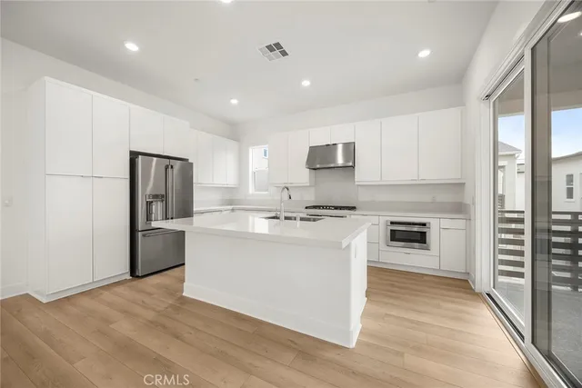 a kitchen with stainless steel appliances a refrigerator sink and cabinets